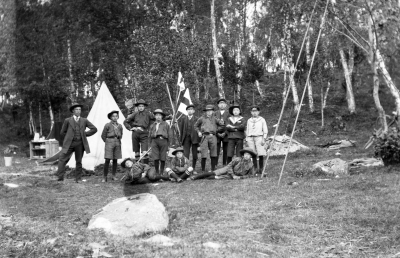 Vimmerby Scoutkår 1911. Sommarläger i Tuna. Stående från vänster. 1. Gustav Johansson, Ledare ( Polis sedan Disponent ) 2. Einar Carlsson - Stenklint 3. Torsten Olsson, Stationsinsp. 4.  5. Oskar Malmberg, död 6. Boda ? 7. Mauritz Sköldborg 8. Walter Karle 9. Erik Gustavi "Flinta", ing i Jönköping Liggande 1. Oskar Bohm - Sköldborg 2. Gustaf Adolf Malmberg 3. Bertil Nyberg   T.E. 