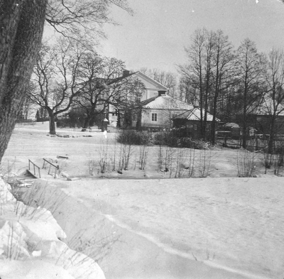 Ålhults Herrgård med den övre flygeln ( som nu är riven ). Fotot tagit på vägen upp mot "alle´backarna". Vid boden längst till höger ligger troligen en isdös.    Okänd 