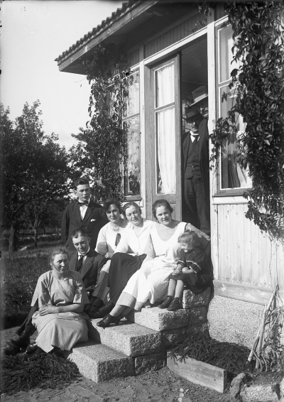 I dörren Karl Nilsson, Nyshult  Aron Eklund, Grägarp. Sittande till vänster Ingrid Hansson gift Nilsson, sittande tvåa från höger Ingeborg Hallberg gift Nilsson, och sittande till höger Inggärd Eklund, gift Juneskog. Fastigheten byggd 1912 av Lars Hallberg, brann ner 1962.