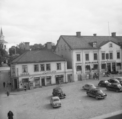 Torget 1957.  Huset till vänster byggt 1913 Huset till höger byggt 1838, Ählströmska huset.   T.E
Bergs, Rudells, Nanna Lindbloms blomsterhandel, Mjölkbar