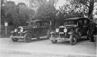 Taxidroskor uppställda vid Källängen på Storgatan
Från vänster: Chaufför Torvald Eriksson med bil Willys - Knight. Bilen ägdes av Johan Adolfsson, Vimmerby
Till höger: Olle Flender Vimmerby. Bilen ägdes av Erik Adolfsson ( son till Johan Adolfsson )