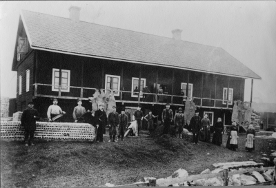 Foto på garverifabrikör C.E. Karlbergs garveri  vid Lögstadsgatan (Lindekulla) i Vimmerby.  Nuvarande ägare: Vimmerby Läderfabriks AB.  Garveriet ligger på nuvarande stadsägan 898. Den fotograferade byggnaden av timmer skadades mycket svårt genom eldsvåda 1936, varefter byggnaden revs helt och hållet och ersattes med byggnad av tegel. Stående nedtill till vänster: 1 "Limmacken"  Oskar Larsson som mest arbetade med limkokning eller tillverkning av avfall från råhudarna.  2 Strömbeck  3 Gustaf Hultin  4 Carl Erik Karlberg  5 Adolf Viberg, bror till sadelmakare Uhrström.  6 "Petrus"                   7 "Dummen", släkt med fjärdingsman  i Biby vid Lögstadsgatan.  8  Karlsson, som utvandrade till USA .Kom senare hem på kort besök. Han bodde vid vägen till Storebro - mitt emot rättare Gustafssons fastighet, i utkanten på staden. Nuvarande Robert Gusafsson i kvarteret Rapphönan är son till nämde rättare Gustafsson.  9  Åhlander, fader till blandannat  lektor Teodor Åhlander, Örebro.  10 " Hejsick", drunknade under sparkstöttingfärd på Krön. 11 "Sågarn", sågade "sticks" se traven, som såldes till stolfabriker.  12  13  Karolina Nilsson  14 Fru Lotta Berg, som bodde i nuvarande Södra Liljerum. Hade en son Edvard Berg.  15.  16,  Uppe på loftgången från vänster            17 Oskar Larsson, bror till C.E.Karlberg. Till vänster om Oskar Larsson står - nästan osynlig- "Linköpings-Karlsson".  18 Högvall, som var från Tuna.  19,  20.                             