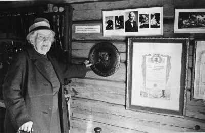 Fru Agnes Wenström i museet 1973 håller i ett porträtt av maken Oscar Wenström gjort av sonen Josef Wenström Silverdalen.  