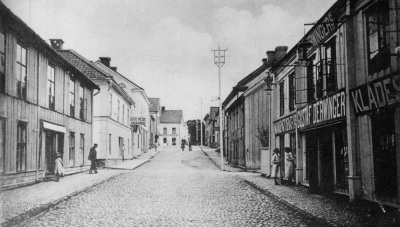 Storgatan. Gustaf Derwingers manufakturaffär. Gasljuslampor över entrén. Flickorna till höger är Lisa och Lilly Palmgren. (uppg. Malmberg)
