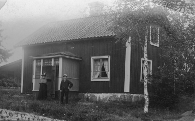 Gumman och Gubben Skoglund vid stugan i Sk...? 