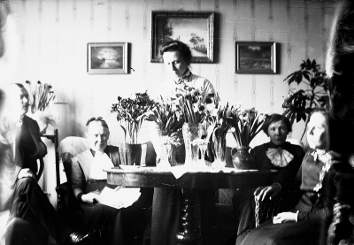 Fem personer runt ett bord. 1 Arvid Forsell son till Beda Forsell, 2 Beda Forsell, 3 Hedvig Forsell, 4 Ingrid Forsell, 5 Ingeborg Forsell, alla tre döttrar till Beda Forsell. Storgatan 5. En födelsedag men vilken vet jag ej, då det är före min tid.