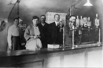 Från vänster: 1 Alma Sandell / Sundell?, 2 Thyra Carlsson (Thyra Bernadina), 3 Karl Stenberg, 4 Sten Carlsson (snippen), 5 Oskar Halling (son till polisman Augustsson), 6 Artur Hagman (förvaltare). Bilden är tagen i stadhotellets källare (Trill in). Spritbolaget hade dessa lokaler under åren 1877 - 1916  .