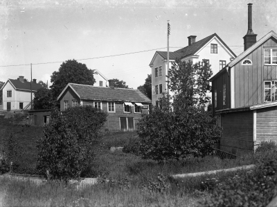Fotot taget från Rönnbärsgatan, s k Krösabacken. Lilla huset i mitten Karlsson på fatet skomakeri och stora ljusa huset, Norrtullsgatan, inhyste bland annat Mattis Brandts strumpaffär / garnaffär