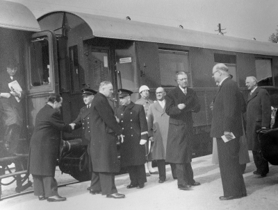 Vid järnvägen vid Konungens salongsvagn.  Från  vänster, 1. General Cederskjöld kungens adjutant, 2. Friherre Palmstierna kungens sekreterare,  4.Gustaf Luning stationsinspektör,  6. Karlsson ( "Trumphult" ) hemvänsman, läderfabriksreperatör,  8. Kung Gustav VI Adolf, 9. Ruben Wagnsson, landshövding, 10. Manne Hofrén landsantikvarie.     