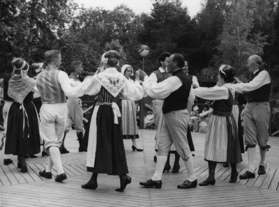 Vimmerby folkdanslag i Hultsfred midsommarafton. Från vänster. 1. Estride Karlsson Södra Vi Fru,  2. Börje Karlsson Hultsfred Sotare,  3. Ture Högsell Hultsfred Teletjänsteman,  4.  5. Barbro Mortling Västervik husmor vid lasarettet i Västervik,  6. Sten Nachtweij Södra Vi Tandläkare,  7. Sivert Georgsson Mariannelund Snickare,  8. Ylva Pettersson Vena Lärare   9. Gunnar Johansson Vimmerby Vaktmästare.   
