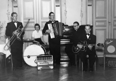 Allan Jonssons egen dokumentation: "  Slutet på 1940 och början på 1950-taleat. Kortet taget på Vimmerby Stadshotell. Detta är en mera tillfällig orkester som vi plockade ihop vid större helger t.ex. Jul och Nyår. Hotellets yrkespianist Nils Metzger vid pianot, Sven-Inge Gustavsson ventilbasun, min fru Lisbeth vid trummorna, Per Lindfors gitarrr och jag som heter Allan Jonsson dragspel. Jag har spelat på Vimmerby Stadshotell, undr tre krögare, nämligen Salander, Cederfeldt och Lundström. Första årens spelningar på hotellet var tillsammans med hotellets pianist Nils Metzger, samt en batterist som hette Ejnar Hultgren. Sedan spelade jag med en egen trio med Sven-Inge Gustavsson ventilbasun, min fru Lisbeth trummor och jag dragspel, någon gång omväxlande med piano. Denna trio spelade en längre tid varje lördagskväll till underhållning och dans.