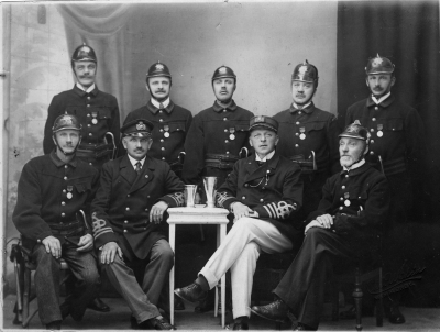 Borgarbrandkåren i Vimmerby. Befälet med ljusa byxorna, Guldsmed Pålsson.                 1. Napoleon Karlsson Vimmerby Skomakare, 2. Oscar Johansson Vimmerby Sadelmakare, Tapetserare, .3 Oscar Svanberg Vimmerby Sadelmakare, 4. Albin/Albert (?) Borgstrand Vimmerby Skomakare, 5. Konrad W. Jönsson Vimmerby Charkuterist, 6. Karl Lindblom, 7. Axel Almér Vimmerby, Brandchef, Plåtslagare, 8. Ludvig Pålson Vimmerby Brandchef /Guldsmed, 9. A.L. Thoren Vimmerby, Smed.   