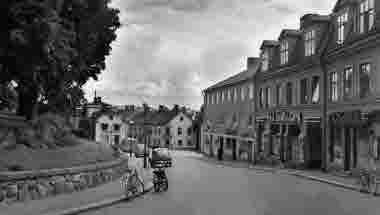 Innan biltrafiken gjorde sitt intåg var de flesta gator mycket smalare än idag. Bilden visar Storgatan österut, det låg hus längs hela kyrkparken, de revs 1929. Ersatte gjorde kyrkterrassen och den stensatta muren som bekostades av vimmerbybördige Skeppsredaren Gustaf Reuter Göteborg. (Bildid: vklba13454) 
