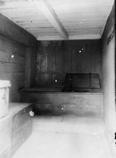 Den gamla toiletten innan den revs. Till vänster kistor med naftalindoftande kläder. En stor lucka uppslagen. Obs! den lilla barnluckan i mitten på fotsteget. T.E.