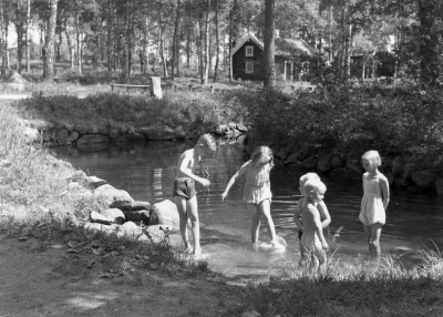 Barn som svalkar sig i Lillån i Gästgivarehagen. Längst t v Sven-Erik Karlsson.

Dok.100526/KG