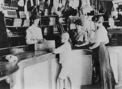 Till vänster: Sylvia Olsson, gifte sig med Bankdirektör Carl Johan Karle, 2 Anna Eriksson Näs, Vimmerby, 3 Fröken Jonsson, tillskärerska, 4 sonen Valter Dervinger död. Tagen i Dervingers affär, Storgatan 1910 talet.   