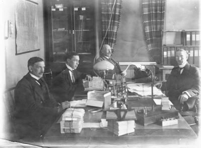 Rådhuset under första världskriget, brödbyrån. Från  vänster Axel Almér, plåtslagarmästare, rådman. Gustav Johansson, polis. Thorsell, rådman. Nils Rundqvist, kontorsskrivare ("strecket") kallad. 