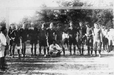 V-by lag vid fotbollsmatch i Oskarshamn 11 sept. 1921.  Från vänster 3. "Grabben" Hallberg, 4. Nils "Pajo" Perfect, 5. "Natte" Magnusson,  6 Knut Karlsson, 7. Ragnar Gustavi,  8. Erik Hallberg, Fabrikör  9. Teodor Gustafson Snickare,  10. Karl Johansson ( Botesgård )  [---] 11. Olle Hagman  12. Erik Gustafsson  13. ( Martin Olsson ? ) Ev. Sten Ek ?  14               