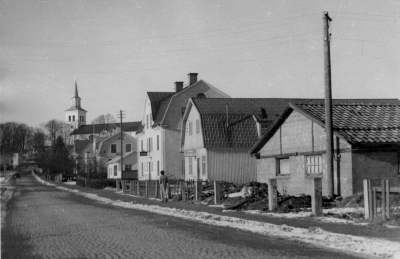 Östra Tullportsgatan (från öster)Till höger Vimmerby Cementfabrik Disponent Svensson. Nästa hus HK:s första lager, huset efter det telegrafen, Fru Hägg, så Lönngren o Gross Bilverkstad, Så Eva Dahlströms hus.  
