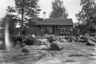 "Idyll vid sjön Krön.

Kaffestugan vid Krön.
1925 tog häradsskrivare Winqvist initiativet till kaffestugans tillkomst.
Majblommekommittén, med Fru Mimmi Ingeström i spetsent, satte fart på rörelsen.
För tre år sedan överläts kaffestugan till åkeriägaren Erik Kask, Vimmerby.
Själva kaffestugan är inredd till serveringslokal, avklädningsrum för damer samt kök, och uppe på taket har man anlagt en trevlig veranda"
ur: Vimmerby Tidning, 17/7 1940


Dok.070711/RS
