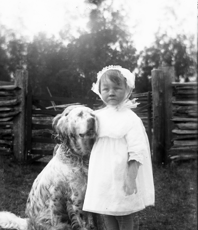 Flicka med hund. Elsa Blomberg född Hallberg. Sommartorpet Grönkullen med min älskade hund Jack. Troligen 1917.