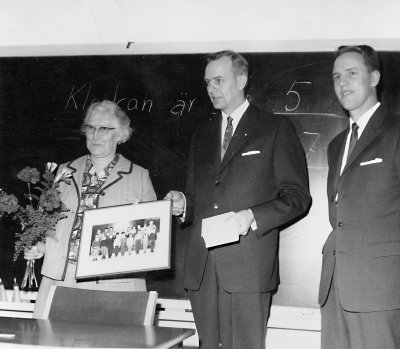 Bästa skolsparklassen i Vimmerby.  Klasskort och blommor överlämnas till lärarinnan Vera Jonsson, av ordförande i Vimmerby sparbank, disponent  Per Dunge och kamrer Curt Dahl             