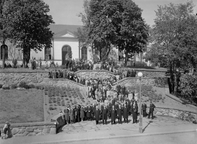 Biskopen är Tor Andrae*, till vänster om honom står Anders Andrae, kyrkoherde i Vimmerby. Till höger om Tor, komminister Eskil Fall. Skollärare Algot Björk i fluga, nedre trappavsatsen till vänster. Karamellhandlare Eek stående i parken till vänster med armen i sida.

* Ledamot av svenska akademien, professor i religionshistoria och ecklesiastikminister i Bramstorps regering sommaren 1936.