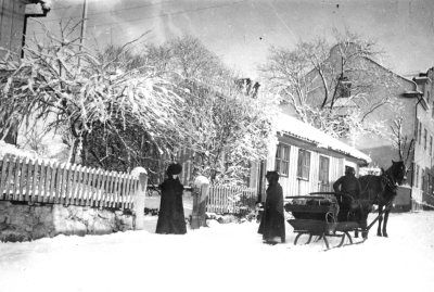 Storgatan väster om torget, utanför tomten nr 19 i Västra kvarteret. Tomten motsvarar Storgatan nr 3, kallas Borgmästargården, (Wahlbergs).  Till v. Borgmästarinnan Wahlberg med Fröken Sigrid Wahlberg.
Observera forna tiders taxi, samt damernas klädsel.   T.E.    
           