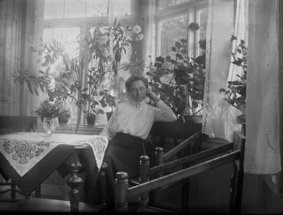 En kvinna sitter vid fönstret. Hedvig Forsell på Solliden.