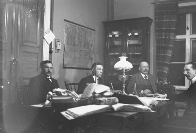 Fyra män i kontorsinteriör 1910-talet.