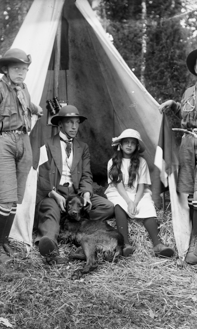 Scouterna
1912 Från vänster sonen till Häradshövding Jarl Prom Hansson. Borgmäst. Vänersborg Gustaf Johansson ( Polis ) kårchef Fröken Ika Hammarskjöld Tuna Hunden hette "Pass" Den graciösa handen, som blottar Ica, tillhör Bertil Nyberg    T.E.
