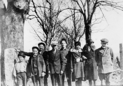 Från vänster 1. Per Danielsson Chaufför, 2. Arne Gross ( sedan Storebro ) 3. Göte Karlsson, Hamra, 4. Bengt  Johansson Älåkra, 5. Harry Liljeblad, Polis Vimmerby.  6. Vivan Johansson, Älåkra 7. Barbro Hermansson, 8. Göte Svensson, Älåkra    Omkring 1935    .

3. Gylfe Karlsson, Hamra, han reste till USA och tog namnet Karl Karlsson. Under kriget var han ombord på amerikansk ubåt, stationerad i Tyskland.
4. Bengt Johansson, fosterbarn hos Klasson, Älåkra . Bengts dotter Elmy finns på Granen.
5. Harry Liljeblad född 1913, fadern arbetade på Fanérfabriken och dog i spanska sjukan 1918. Harry bodde med sin mor i Aby, han var familjeförsörjare och slapp göra rekryter, arbetade på Fanérfabriken. Harry och senare fru Daga var med och startade 
frisksportklubben Apollo 1935. Hårfrisörskan Daga Palmgren och Harry Liljeblad gifte sig 1938. I början på 1940-talet föreslog polis Ekman, morbror till Daga att Harry behövdes som polis. Han började direkt och gick senare kurser på polisskolan,
så småningom överkonstapelkurs. Paret bodde i 3: e huset nerom Beijerska huset. Liljeblad arbetade som polis i 47 år. Han var frisksportare och idrottsman.
6. Vivan Johansson, Älåkra, flyttade senare till södra Rothult och senare längre upp i mellan Sverige.
7. Barbro Hermansson född 1916 bor nu på Borgaregatan 26 i Vimmerby.  Barbro är född i Stockholm, hon kom som fosterbarn till Slättfallstorp, fostermor dog och fosterfar gifte om sig, då fick Barbro flytta till hans syster Ida.
Barbro 10 år och tant Ida flyttade till Ljungåkra, senare  flyttade de tilll Aby nära Älåkra kvarn. Barbro gick i Källsåkra skola, när hon gick i  fortsättningsskola bodde de i Aby men Barbro var så blyg  så hon ville inte gå i stan utan gick till Källsåkra.
Barbro tog körkort 1953 och blev då också medlem i Vimmerby kvinnliga bilkår, Barbro tror att bilden är tagen i Vinketomta.
8. Göte Svensson, Älåkra, omkom i övre tonåren. Han cyklade i Älåkrabacken, gick omkull och fick styret i magen, han omkom av skadorna, enligt Nils Stenberg.
Uppgiftslämnare: Elsy Nilsson  Storebro 2002

Dok.090203/SJ