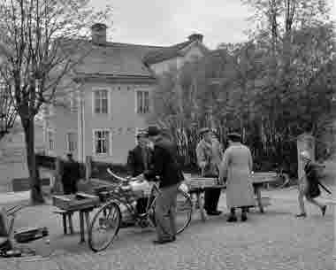 Platsen där du står nu kallades förr “Fisktorget”. Här var det påbjudet att försäljningen av fisk skulle ske. I "Torghandelsstadgan för Vimmerby stad från 1950”, stod det inskrivet var i centrala staden man skulle sälja vilken sorts vara. Här skulle förutom fisk och skaldjur även saluhållas hantverksmässigt tillverkade trädgårdsmöbler och laggkärl. (Bildid: vklba9479) 
