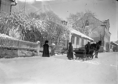 Borgmätare gården
Storgatan

" Denna bild är tagen omkring år 1910 utanför Tomten nr 19 i Västra kvarteret. Tomten motsvarar Storgatan nr 3 och kalllas ännu i dag ibland för  " Borgmästaregården ". Bilden visar hur forna tiders " Taxi " fungerar vintertid och hur ett sådant " åkdon " såg ut på den tiden. Klädseln på de gamla damerna, fast de kanske inte var så gamla, är synnerligen intressant ".