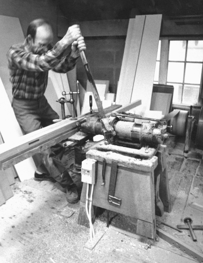 Bildtext: Stämmaskin, håltagning för tapparna.
Dokumentationsfotografering av tillverkningsprocessen på Snickargården.
Vårvintern 1988
Tillverkning av fransk pardörr.
Avbildade personer:
Tönnes Andersson
Bernth Ericsson
Lillan Ericsson
Alvar Andersson
Bildmaterialet användes senare till en skärmutställning om Snickargården som visades på Vimmerby Bibliotek