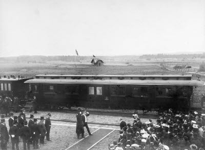 Kung Oscar II salongsvagn. I bakgrunden skyttepaviljongen som sedan flyttades  till norr om staden.   
Personerna i mitten, Kung Oscar II och kronprins Gustav V