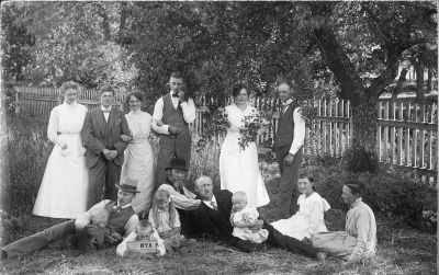 Familjen Lindström, stående från vänster  Signe Lindström, Axel Lindström ( dövstum ), Tekla Lindström, Erik Lindström, Hilda Lindström, Thure Lindström. Sittande från vänster  Gustav Lindström med Olle i famnen, Sven läser tidningen, Ingrid, Farfar August Lindström, Pappa Axel Lindström med Stina i famnen, Greta, Mamma Hilma Lindström  