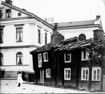 "Magkrampen" brann 1901, revs året efter och nya huset nuvarande Vikbergs var färdigt 1902. Huset brann 1901 revs 1901 och nya huset nuvarande Wikbergs var färdigt 1902 (se foton från kungabesöket 1902)  "Eldsvåda. Den 30 maj vid half 8-tiden på morgonen uppstod eldsvåda uti Eklundska gården intill stadshotellet i Wimmerby. Så fort faran varsnades och alarm gifvits, skyndade brandkåren till samt lyckades, efter raskt arbete, släcka elden, som dock hunnit förstöra byggnaden. Handlanden C. Sellqvist, som bor i gården, fick mycket förstört. En gammal gumma, fröken Sofia Crusell, bebodde ett rum å öfra botten. Hon öfverraskades af elden, men lyckades komma ut och rädda sig, ingen menniska blef skadad. Huru elden uppkommit är okändt. Det brunna var lågt försäkradt, nämligen byggnaden för 2,000 kr. och hr. Sellqvists lösegendom för 1,500 kronor. Släckningen var ovanligt rask samt hedrar alla som deri deltogo, ingen nämnd och ingen glömd.Bland annat, som förstördes af elden, var en ny velociped, tillhörig en arbetare.             Vimmerby Tidning  30.5-1901. T.E.

Ludvig Svensson. Detta hus brann 1899 och togs sedan en vy av detsamma och skickades som vykort till amerika till ett f.d. biträde i Barkmans affär V. Nilsson, hon i sin tur tog detta fotografi och sände skomakarmäst. Ludvig Svensson detsamma av vilken jag bekommit detsamma. Kallades (Magkrampen) jag var med och slägte eldsvådan vid 9 - tiden en morgon, det var bageri på nedre botten beboddes av en familj Sällquist  Vimmerby den 13/4 1986 Axel Almér. T.E.
