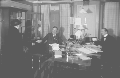 Två män o en kvinna i kontorsinteriör 1910-talet.