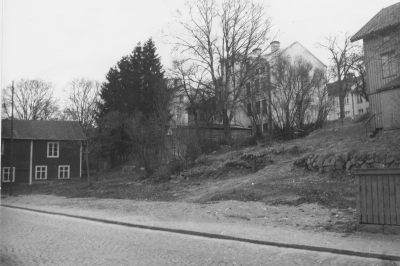 Till vänster: Barkliden
Det röda huset nere till vänster på Sevedegatan, är Axel Ståhls första möbelfabrik, senare Arthur Håkanssons Möbelaffär. Bakom denna och upp mot Storgatan är Barkliden. De stora granarna är en granhäck på Emil Anderssons fastighet, Storgatan 13 , det stora vita huset. I det närmaste grå huset, som endast ses till hälften, bodde Anna Larsson, tvätterska, fram till rivningen.Dessa hus revs då HSB byggde.