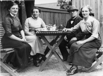 Från vänster Signe Andersson arbetade i faderns mössmakeri, Elisabeth Andersson arbetade i faderns mössmakeri övertog sedan affären och gården, ( död 1977 ), Hampus Wiktor Andersson, stadens sista mössmakare, död 1924, Paula Andersson sedan gift med polis, disponent Gustav Johansson.  Hampus Wiktor Andersson köpte fastigheten Storgatan 23, år 1878.  Tidigare fanns ett Hökeri i fastigheten ägt av en Pettersson.     