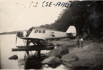 Pilot Arenberg på sjön Krön omkr. 1931.  Södra Vi    
Planet är en Junkers F 13 och de planen tillverkade man mellan 1919 och 1932. Typen var det första civila helmetallplanet. 
Pilotens cockpit var inte helt slutet så denne fick utstå elementens raseri i alla dess former och utöver detta tillkom ju den intensiva luftströmmen från propellern som satt framför. Ett jobb för den sanna friluftsmänniskan.
Passagerarutrymmet var däremot slutet och till och med uppvärmt. Planet kunde också utrustas med vanligt landningsställ vilket kanske var det vanligaste.
Uppgiftslämnare Jan Sandgren, Bua Halland
