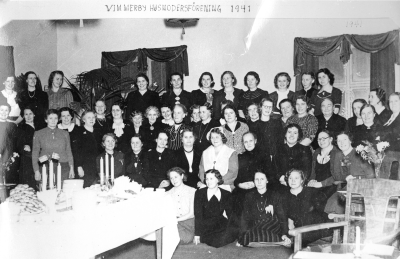 Vimmerby Husmodersförening.  1. Britta Svan,  2. Greta Brantemo Vimmerby 3. Astrid Olsson Vimmerby 4. Lydia Andersson 5. Fru Vaster, lärarinna 6. Signe Jonsson 7. Anna Nilsson Vimmerby 8. Anna Carlberg Vimmerbyby 9. Herta Dalgren 10. Elsa Olsson, lärarinna  11. Greta Hammarstrand 12. Ebba Sköldborg 13. Annie Svensson Vimmerby 14. Fru Demerland (tyska) 15. Agnes Gustavsson 16. Ketty Ståhl 17. Edit Ek Vimmerby 18. Johansson Vimmerby 19. Hanna Vetterström 20. Jenny Verner 21. okänd, 22. Gerda Hultenheim 23. Anna Sandberg Vimmerby 24. Nanna Malmberg, fru 25. Astrid Sandström 26. Fru Helga Leufstedt 27. Karin Nilsson (Topsy) 28. Lotta Hallberg Vimmerby 29. Frideborg Pettersson 30. Sofia Johansson 31. Alva Karlsson 32. Selma Gustavsson 33. Märta Dunge 34. Astrid Bälter 35. Fru May Severin 36. Fru Grönqvist (Gerda) 37. Linneá Alkvist 38. Anna Johansson 39. Fr Skutskär (glömt namn) 40. Fru Gustavsson Vimmerby Fru Hammarlund ? 41. Fru Karsmark 42. okänd 43. Anna Lisa Jonsson 44. Elvira Ståhl 45. Lisa Carlsson 46. Fru Castenfors 47. Elsa Dalén.    