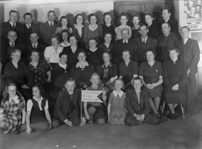 Vimmerby Kooperativa Kvinnogille.Sittande på golvet från vänster Rut Kempe (glasögon), Gunnel Svensson, Roland Gustavsson, Stenberg, Anita Lind, Bernt Lind.  Andra raden fr.v. 1. Aina Svensson, 4. Ella Älg, 5. Elvira Andersson (Kantus), 6. Lisa Lind, 8. Anna Hägg.  Tredje raden fr.v. 7. Signe Gustavsson, 8. Frans Gustavsson, 9. Oskar Leander. Fjärde raden fr.v 3. Olle Pettersson, 5. Lizzie Svensson. Eriksson. 6. Birgit Pettersson