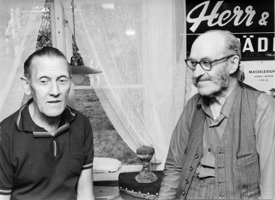 Till vänster 1  Thorvald Eriksson,  2  Erik Jacobsson, skräddare, taget i Gästgivarhagen vid hans verkstad som han skänkte dit i Juli 1972.        