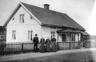 Läg. Vi 1:7 Vilund, Södra Storgatan 10. S. Vi omkring 1910 . Personer på kortet: 1. Kyrkovaktare Per Johan Johansson, Vilund, f. 3-10-1832 d. o. 1918. 2. Hans hustru Lovisa Josefina Johansson, Vilund, f. 5-7-1829 d. 6-4, 1915. Hennes dotter i 1:a giftet Hilda Andersdotter. g. m Elof Jonsson Vilund f. 11-1-1859, d. 9-5-1923. 4. Matilde N.N. hon reste till Amerika o. 1912 uppgifterna har lämnats  av  Annie o. Konrad Karlsson Hälsobrunnen S-Vi o. Leonard Carlsson, Ivarslund, Södra Vi 26-8-1974.  T.E.