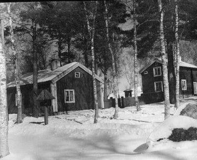 Huset till vänster Östra tullstugan som var belägen vid Storgatan, där trappan till kyrkterassen går upp, flyttades dit 1927. 