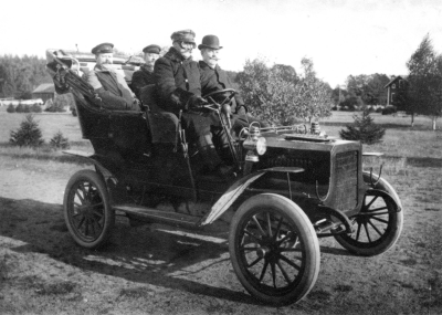 Hultsfreds slätt 12 augusti 1906. 
Föraren K.A. Pettersson Linköping troligen också ägare till bilen. 
Baksäte fr. v.  Järnhandlare John Sjöholm. Vimmerby  hö :  Manufakturhandlare Gustaf Derwinger Vimmerby
I framsätet handlare Erhardt Peterson Vimmerby. 
Bilmärke Reo. Började tillverkas år 1904.    