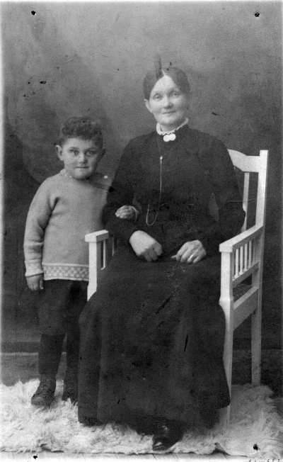 Fru Anna Andersson ( ? ) Storgatan 81 Ängelholm samt Edvardo Walentin född 17/9 1914. Kortet taget i mars 1919.