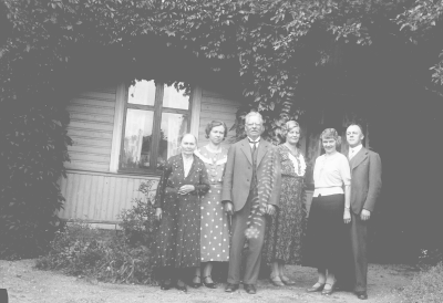 Familjefoto framför hus.